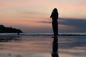 Fototapeta premium people using smart phone for taking a sunset photo at the beach