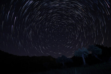 A view of the stars of the Milky Way with a mountain top in the foreground. Night sky nature summer...