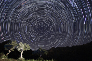 A view of the stars of the Milky Way with a mountain top in the foreground. Night sky nature summer...