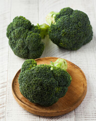 Raw fresh broccoli on a wooden white background. Vegetables, harvesting.