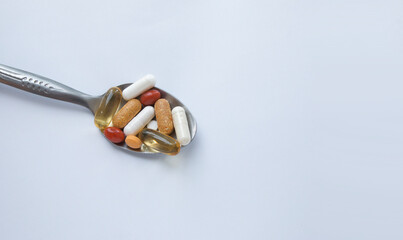 Pills in a spoon top view with copy space. Mental health dietary supplements and vitamins. 