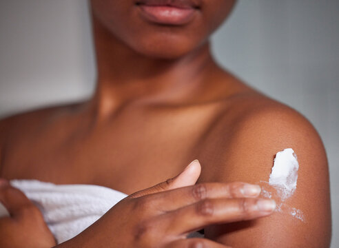Body care, skin and closeup of woman with lotion for moisturizing, health and wellness. Cosmetics, creme and zoom of a female person with spf, sunscreen or moisturizer after a shower in the bathroom.