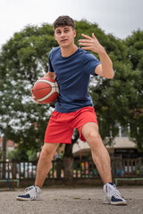 Obraz premium One caucasian teenager stand on basketball court with ball