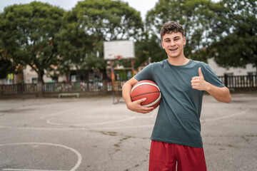One caucasian teenager stand on basketball court with ball