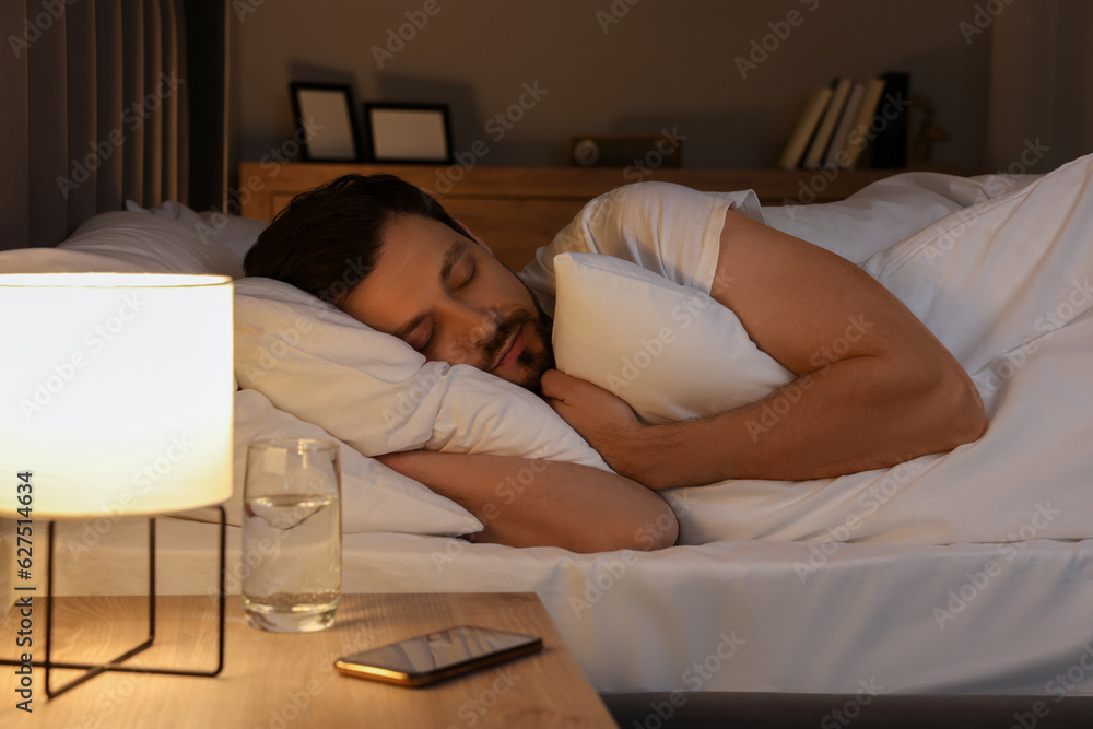 Poster Handsome man sleeping in bed at night