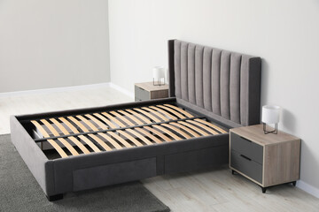 Comfortable bed with storage space for bedding under slatted base in room
