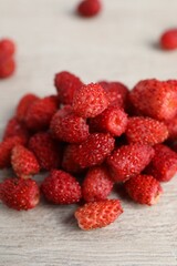 Pile of wild strawberries on white wooden table, closeup