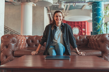 Female freelancer enjoying rest break in co-working space and looking at camera