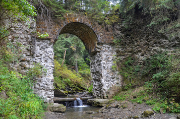 Picturesque ruins of the narrow-gauge viaduct carriage bridge in the village of Vorokhta,...