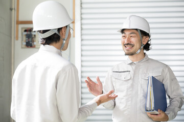Workers at a factory facility checking work while conversing on site Have a safe day today!