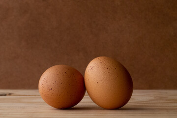 two spotted eggs placed in the center on a wood and darker wood background simple rustic style with shading