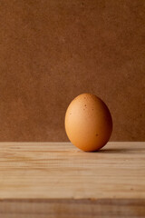 a photoproduct of a standing egg with a distinctive stain, on some wood giving it a rustic style and with a shading on it, cut vertically