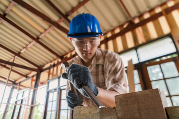 Carpenter working on his desk in construction design Wear a helmet and goggles to prevent dust.