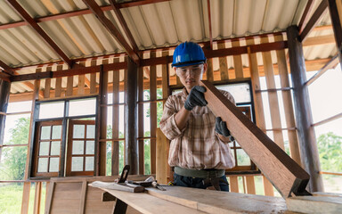 Carpenter working on his desk in construction design Wear a helmet and goggles to prevent dust.