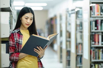 University students reading books in library for research.