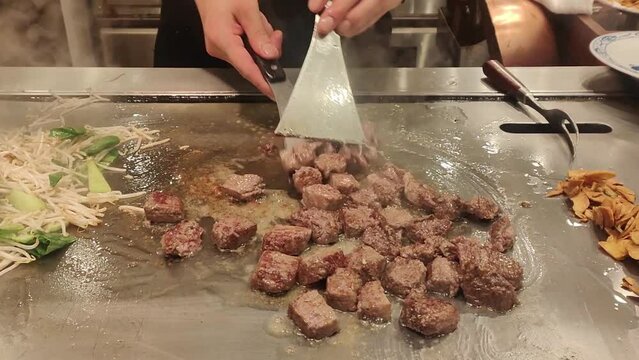 Chef cutting and cooking Kobe beef steak teppanyaki