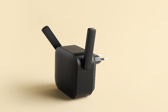 Black WiFi repeater on beige background