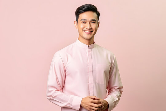 malay man wearing baju melayu isolated on pink background