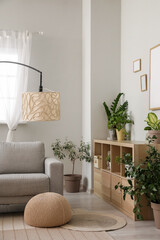 Interior of living room with sofa, lamp and houseplants