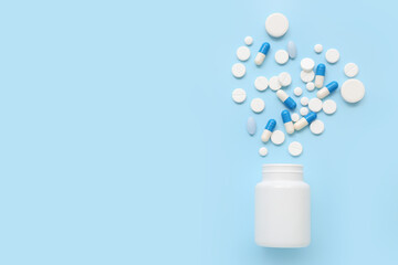 Bottle with pills on blue background