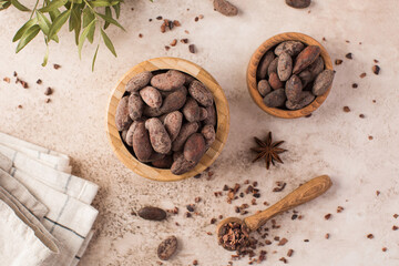 Cocoa beans in a wooden plate on a dark gray background. Roasted cocoa beans.