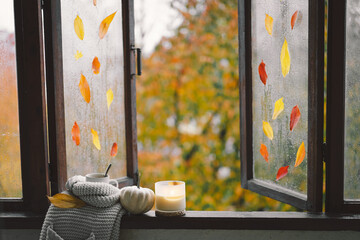 Sweet Home. Still life details in home on a wooden window. Sweater, candle, hot tea and autumn decor. Autumn home decor. Cozy fall mood. Thanksgiving. Halloween. Cozy autumn or winter concept.