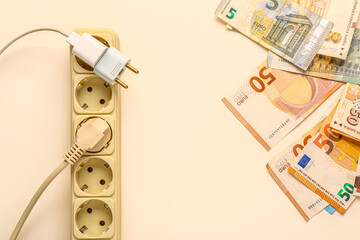 Power socket with plugs and money on white background. Electricity bill concept