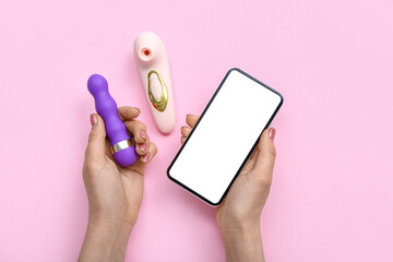Woman with mobile phone and vibrators on pink background
