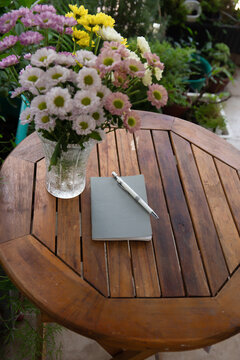 Photo of notebook and pencil on the table in the garden 