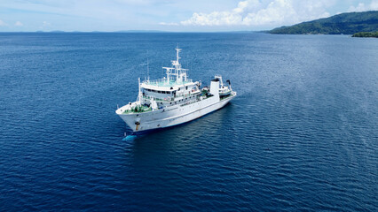 Ship in the sea . Research vessel at sea. Aerial view of a large white ship parked near the shore of a tropical island.