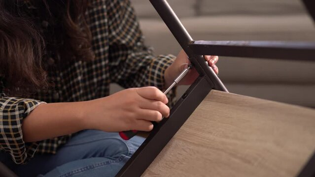 women adjusting or repair assembling chair Furniture at home diy concept.
