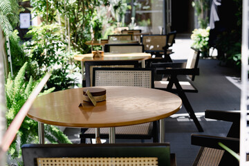 Outdoor empty cafe terrace with  plants tables and chairs - obrazy, fototapety, plakaty
