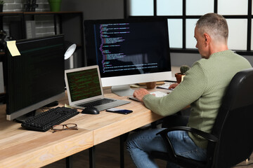 Mature male programmer working in office