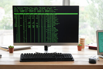 Computer monitor with command line interface at programmer's workplace in office, closeup