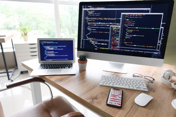 Computer monitor with programming code at programmer's workplace in office