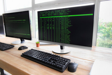 Computer monitor with command line interface at programmer's workplace in office, closeup