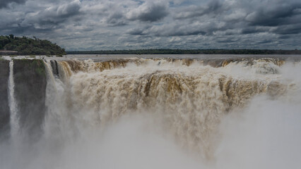 Powerful streams of the waterfall descend into the gorge, foaming. Spray and fog. Tropical...