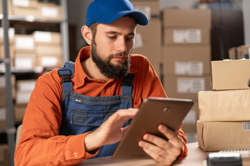 Portrait of a professional male worker uses digital tablet with inventory checking software in the retail warehouse. Delivery, Distribution Center.