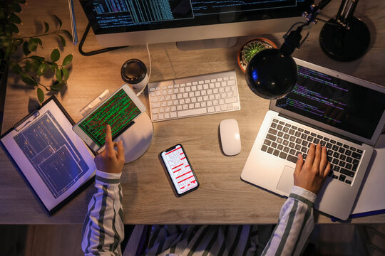 Female programmer working in office at night, top view