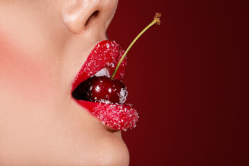 Beautiful woman with sugar lips and red cherry on color background, closeup