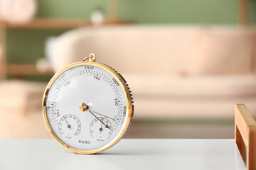 Aneroid barometer on white table in room, closeup