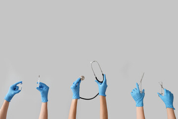 Female doctor's hands with medical tools on grey background