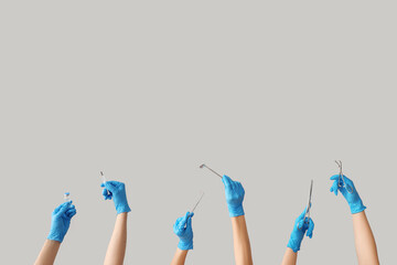 Female doctor's hands with medical tools on grey background