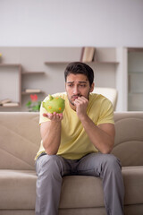 Young man in unemployment concept at home