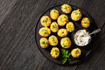 baked stuffed red potatoes on black plate