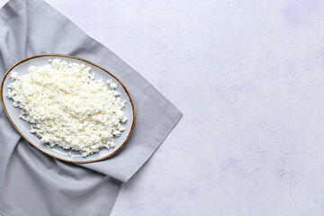 Plate with fresh cottage cheese on grey table