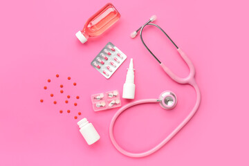 Stethoscope, pills and nasal spray on pink background