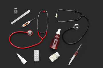 Composition with stethoscopes, pills and medical supplies on black background
