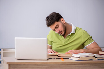 Young male student sitting in front of whiteboard