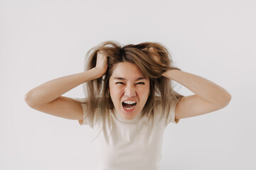 Fototapeta premium Angry face of asian woman in white t-shirt isolated on white.